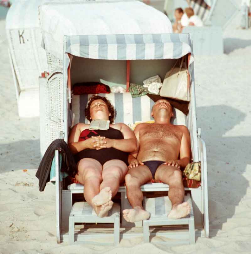 Ein Paar sonnt sich in einem Strandkorb an der Ostsee bei Bergen auf Rügen.