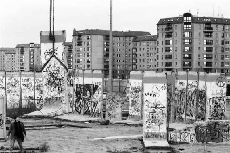 Als Mahnmal aufgestellt Mauersegmente am Potsdamer Platz, ein Segment hängt in der Luft am Kran.