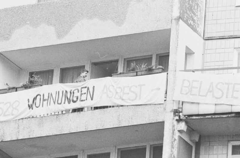 Transparent am Balkon einer Plattenbau-Wohnung mit dem Spruch: 628 Wohnungen Asbest belastet.