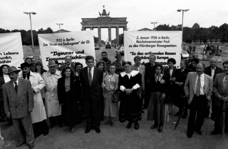 Sintis and Roma demonstrate on Pariser Platz in front of the Brandenburg Gate in the Mitte district of Berlin. Demonstrators stand together and hold placards