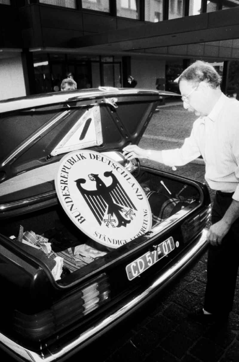 Demontage vom Vertretungsschild der BRD (Ständige Vertretung) in der Hannoverschen Strasse. Mann legt das Schild in den Kofferraum eines Mercedes-Benz.