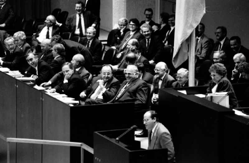 Gregor Gysi spricht während der 1. Sitzung des Gedamtdeutschen Bundestag im Reichstag in Berlin. Politiker wie Lothar de Maiziere (1.von links), Theo Waigel (2. von links), Wolfgang Schäuble (3. von links), Hans-Dietrich Genscher (4. von links), Helmut Kohl (5. von links) und Rudolf Seiters (2. Reihe rechts) höhren zu und lachen.