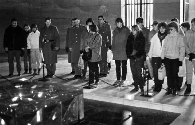 Joint visit by soldiers and army members of the NVA fighter squadron 'Heinrich Rau' and young people from a civilian mentor brigade in front of the 'Eternal Flame' in the national memorial against the victims of war and fascism in Schinkel's 'Neue Wache' on the boulevard Unter den Linden in the Mitte district in Berlin East Berlin on the territory of the former GDR, German Democratic Republic