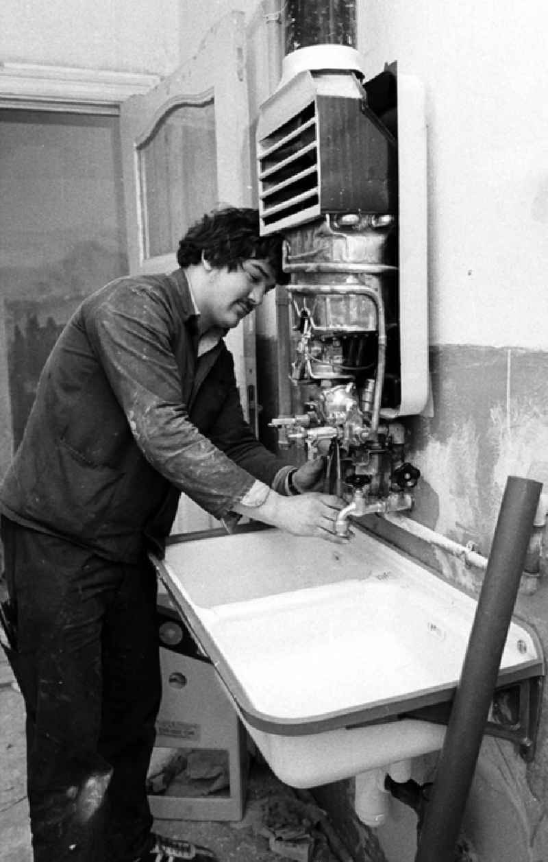 Ein Arbeiter setzt in einem Altbau-Wohnhaus in der Britzer Straße in Niederschöneweide einen Boiler instand.