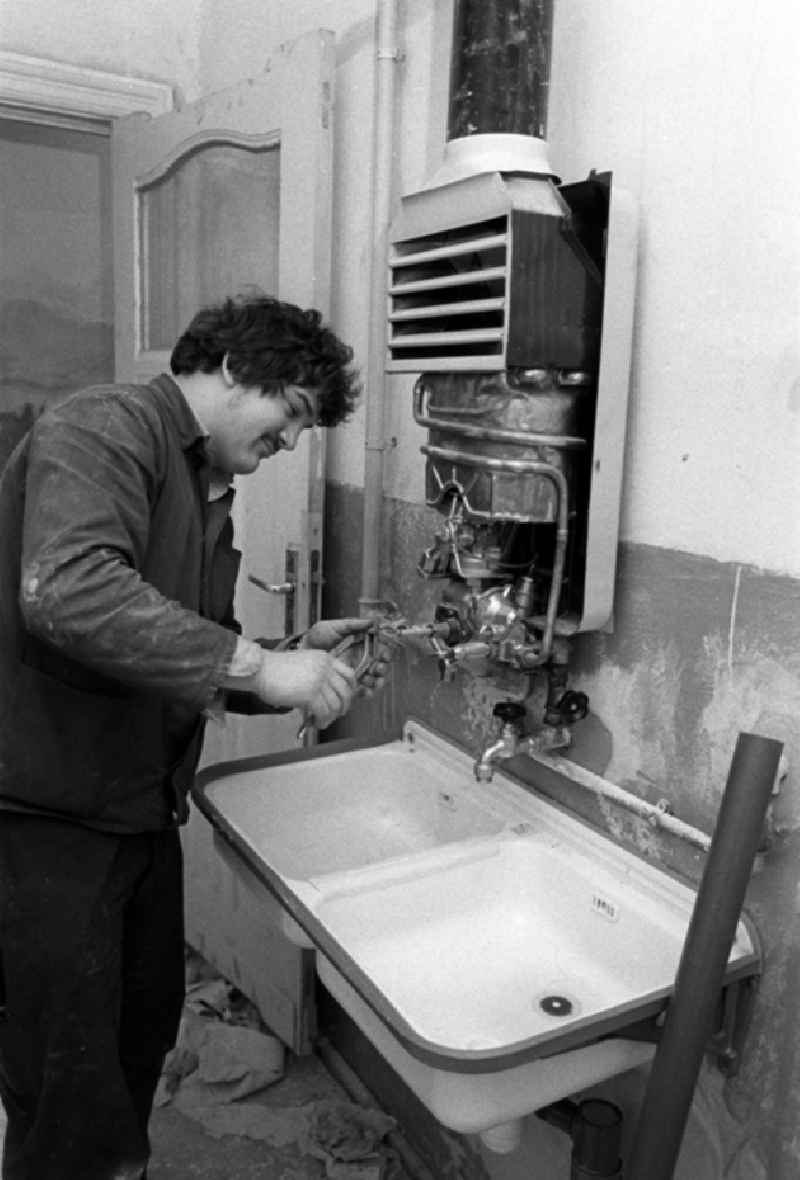 Ein Arbeiter setzt in einem Altbau-Wohnhaus in der Britzer Straße in Niederschöneweide einen Boiler instand.