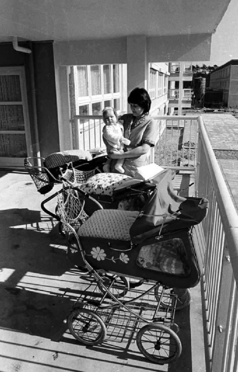 Eine Erzieherin steht auf dem Balkon in einer Kinderkrippe in der Salvador-Allende-Straße in Berlin-Köpenick und hält ein Baby auf dem Arm. Drumherum Kinderwagen mit schlafenden Babys.