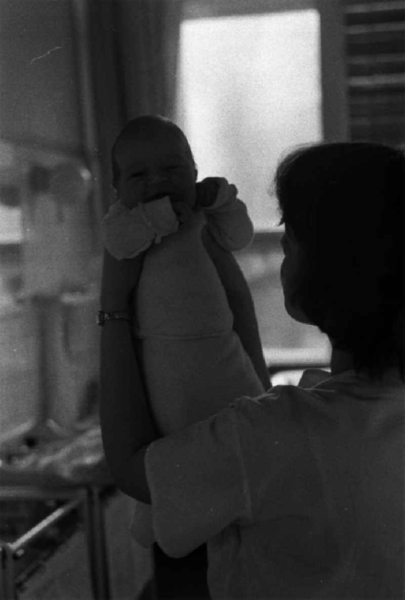 Auf der Neugeborenen- und Wochenstation der Charité / Frauenklinik. Die kleine Petra Franz in den Händen einer Schwester.