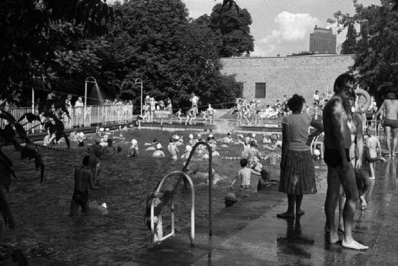 Sommerfest im Monbijoupark. Kleine Badegäste planschen und schwimmen im Freibad. Im Hintergrund das Charité-Hochhaus.