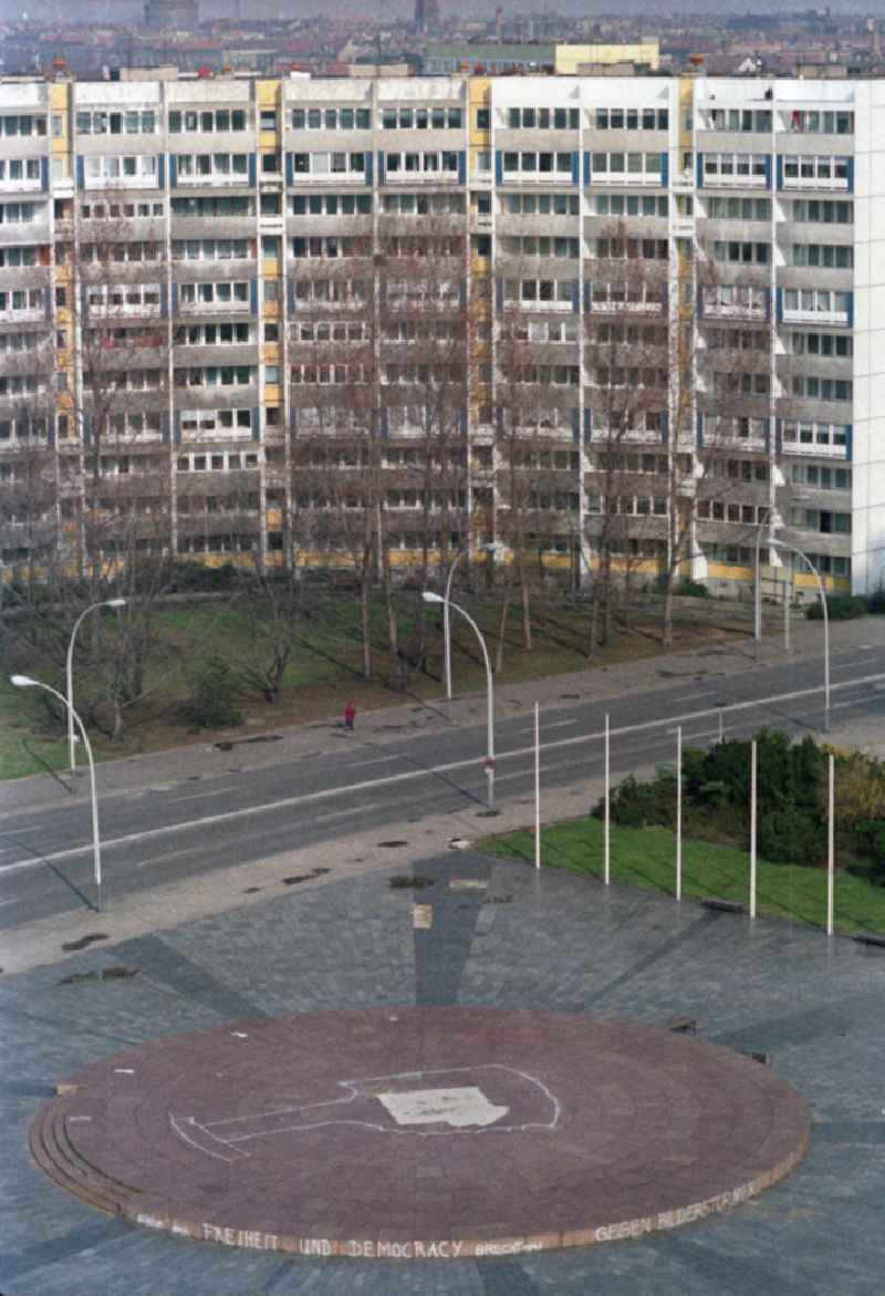 Blick auf den Leninplatz. Mit dem Spruch 'Freiheit und Democracy Brecht 1947' am rotem Sockel mit 26 Meter Durchmesser auf dem das 19 Meter hohe Lenin-Denkmal Stand. Der heutige Name lautet Platz der Vereinten Nationen. Heute steht an dieser Stelle ein Springbrunnen bestehend aus 14 Findlingen. Plattenbau im Hintergrund.