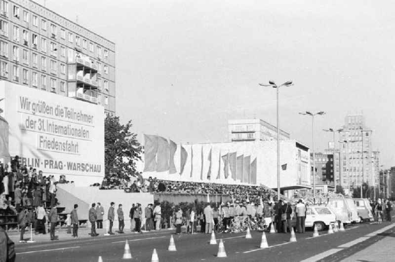 Eröffnung der 31. Internationalen Friedensfahrt auf der Karl-Marx-Allee. Die Teilnehmer sind vor der Ehrentribüne angetreten; rechts hinter ihnen Manschaftsbusse vom Typ B100