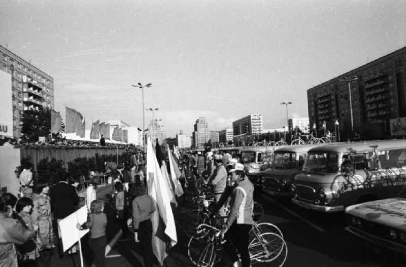 Eröffnung der 31. Internationalen Friedensfahrt auf der Karl-Marx-Allee. Die Teilnehmer sind vor der Ehrentribüne angetreten; rechts hinter ihnen Manschaftsbusse vom Typ B100
