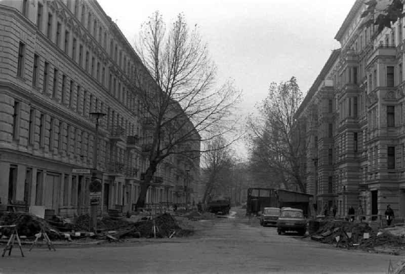 Blick auf Altbau-Wohnhäuser in der Husemannstraße in Richtung Kollwitzplatz im Prenzlauer Berg. Auf der Straße erfolgen Bauarbeiten. Auf der Straße stehen Autos vom Typ Wartburg und Lade (Rückansicht).