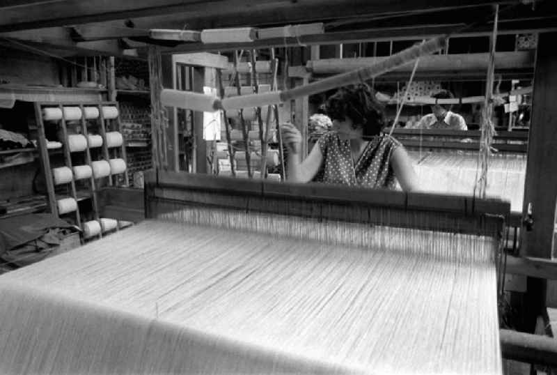 Arbeiterinnen betätigen in einer Weberei in Berlin den Webstuhl und fertigen textile Flächengebilde / Stoffe.