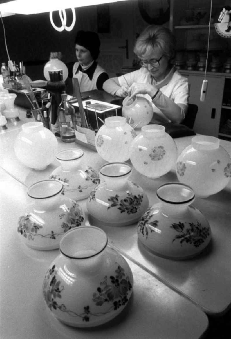 Glasmalerei / Glasmalerinnen der PGH des Kunsthandwerkes arbeiten in ihrer Werkstätte in der Schreinerstraße 58. Blick über Vasen die zum trocknen zusammen stehen auf die Arbeiterinnen beim verzieren / bemalen von Glasvasen.