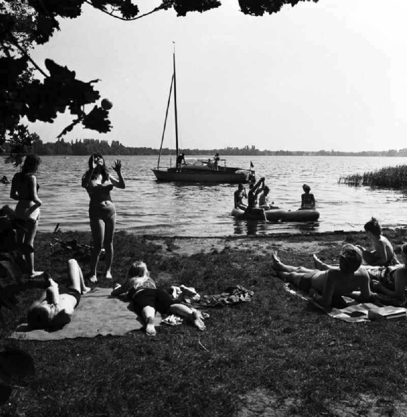 Jugendliche an der Badestelle auf dem Internationalen Campingplatz (Intercamping) bei Schmöckwitz in Berlin-Köpenick am Ufer des Krossinsee. Ein Segelboot ist im Hintergrund auf dem See.