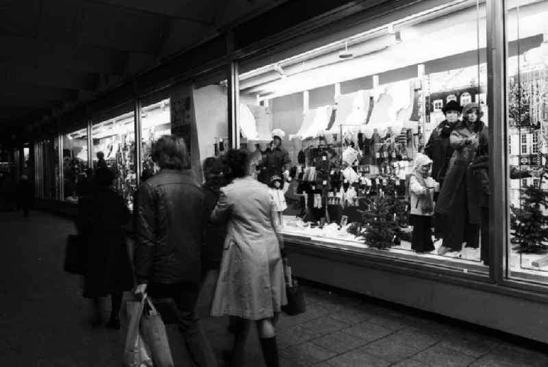 Passanten gehen an der weihnachtlichen Schaufensterdekoration vom CENTRUM Warenhaus am Alexanderplatz in Berlin-Mitte vorbei.
