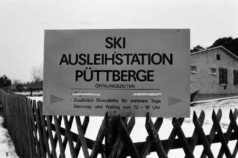 Nah: Schild der Ski Ausleihstation Püttberge in Berlin-Wilhelmshagen. Die hier lagernden Abfahrts- und Langlaufski sind in der Regel nicht für den sofortigen Gebrauch in dem hügligen Gelände am östlichen Stadtrand Berlins gedacht, sondern für die Urlaubsreise nach Thüringen oder in das Erzgebirge.