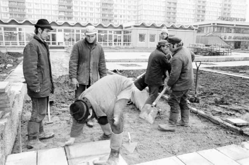 Paving work and laying pavement slabs in the green areas in front of the facades of an industrially manufactured prefabricated large housing estate on Weissenseer Weg (formerly Ho-Chi-Minh-Strasse) in the district of Lichtenberg in Berlin East Berlin in the area of ​​the former GDR, German Democratic Republic