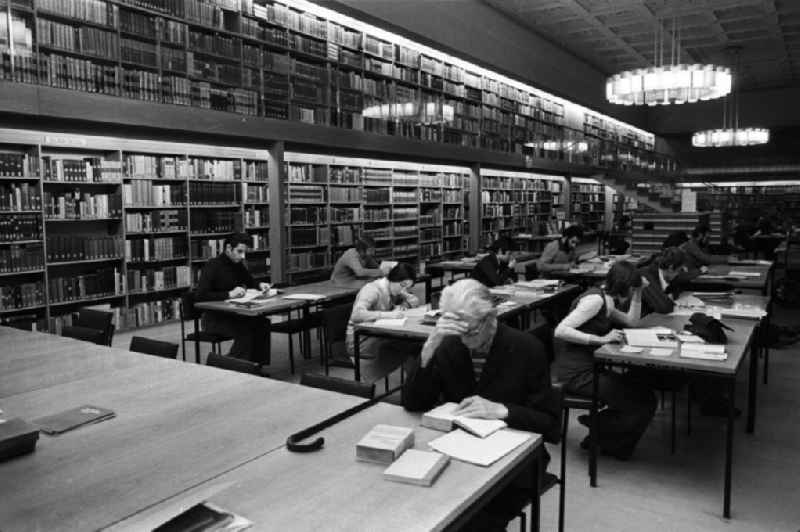 Blick in den Lesesaal der Berliner Stadtbibliothek, Benutzer sitzen an Tischen und lesen.