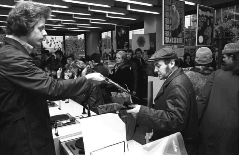 Musik-Schalplatten und Kassetten-Verkauf am Alexanderplatz, Kunden vor Plattenspielern.