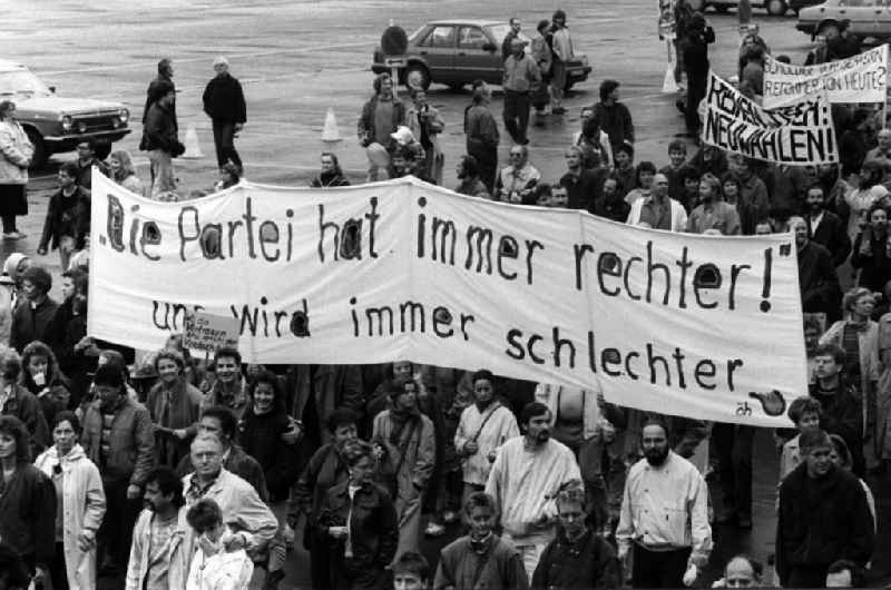 Plakate mit politischen Forderungen werden am Berliner Palast der Republik mit dem Sitz der Volkskammer vorbei getragen. Berlin erlebt am