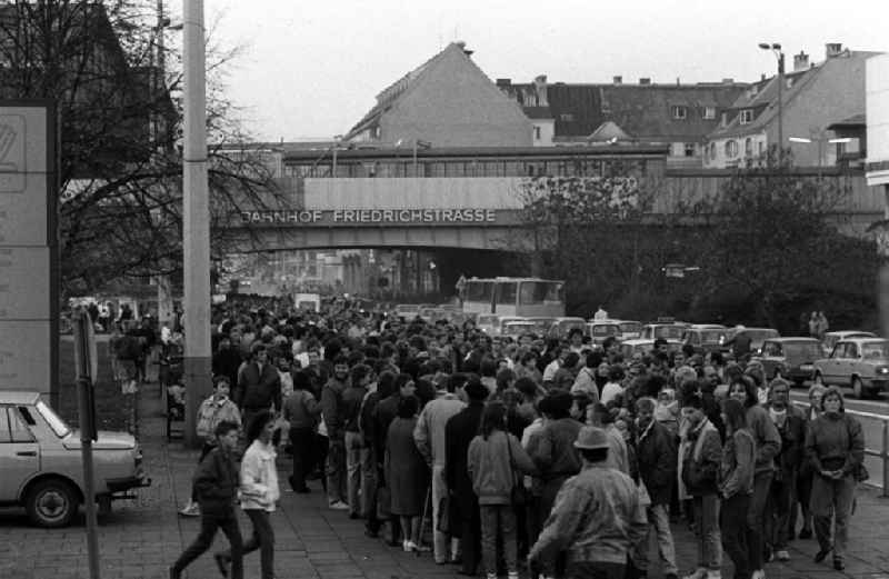 Etliche zehntausend Menschen aus Berlin und vielen Teilen der DDR stehen am Bahnhof Friedrichstraße zu einem Abstecher nach Westberlin an. Die Schlange ist mehr als einen Kilometer lang, denn die Grenzübergangsstelle 'Tränenpalast' befindet sich auf der anderen Seite des Bahnhofs. Am Abend zuvor hatte SED-Politbüromitglied Günter Schabowksi in einer vom Fernsehen direkt übertragenen Pressekonferenz gesagt: '... haben wir uns dazu entschlossen, heute eine Regelung zu treffen, die es jedem Bürger der DDR möglich macht, über Grenzübergangspunkte der DDR auszureisen.' Das trete ab sofort in Kraft. Das Resultat war ein sofortiger Ansturm der Massen auf die Übergänge und völlig rat- und hilflose Grenzschützer. Sie taten das einzig Machbare und ließen die Menschen passieren. Erst Wochen später normalisierte sich alles.