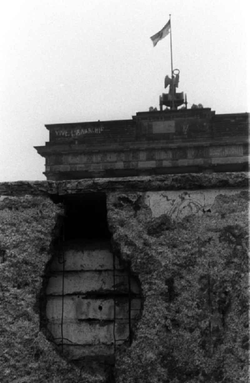 Blick über die bereits löschrige Mauer auf das Brandenburger Tor. Als Erinnerung wurden gern Stücke der Mauer mitgenommen, so entstanden die Löscher, sie hießen auch Mauerspechte.