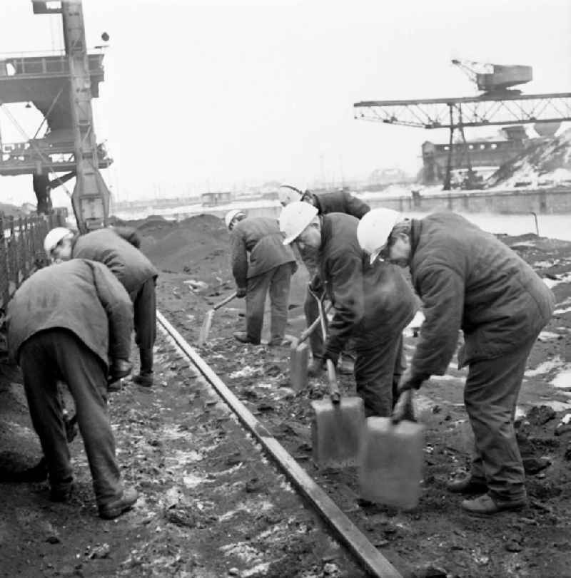 Bauarbeiter mit Helm und Schaufel legen den Gleisanschluss / Gleise am Kraftwerk Klingenberg in Lichtenberg frei. Das Elektrizitätswerk war der bedeutendste Kraftwerksneubau der 192