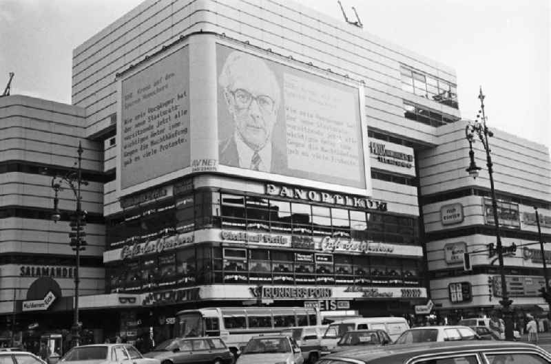Blick über die dicht befahrene Einkaufsstraße Kurfürstendamm in West-Berlin. Über eine Videowand - hier ein Porträt des DDR-Staats- und Parteichef Erich Honecker - werden die Bürger über die Entwicklungen in der DDR informiert.