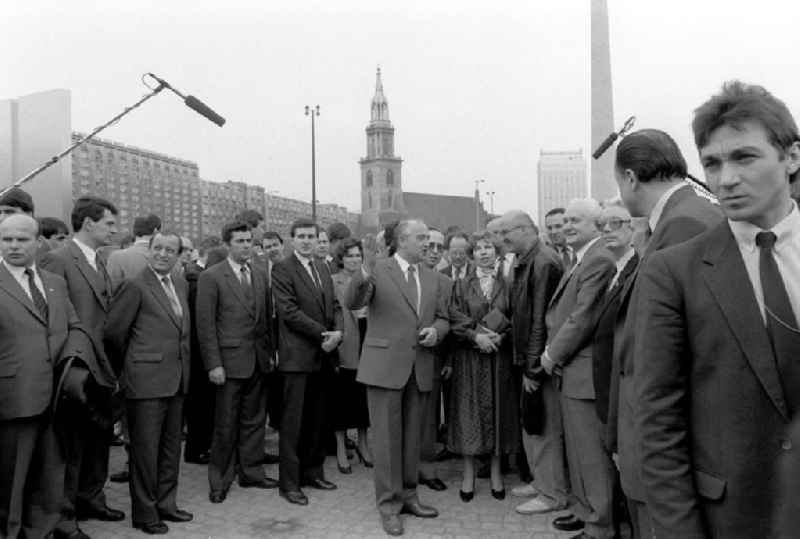 Der sowjetische Partei- und Staatschef Michail Gorbatschow (M) trifft als Gast des bevorstehenden XI. SED-Parteitages bei einem Stadtrundgang auf 'ausgesuchte' Gesprächspartner. Der Parteitag vom 17. - 21. April steht im Zeichen der Kontinuität der SED-Hardliner, die sich den Reformen Gorbatschows verweigern. In einer Gastrede macht Gorbatschow weitere Vorschläge zur Abrüstung, die vor allem auf die Reduzierung konventioneller Waffen in Europa abzielen.