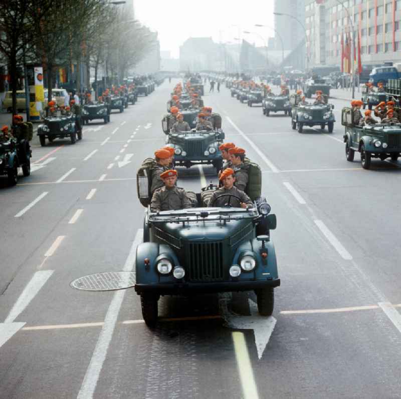 Parade der NVA auf der Gertraudenstraße zum 25. Jahrestag der DDR. Soldaten / Fallschirmjäger mit typischen rotem Barett fahren in Geländewagen vom Typ GAZ-69. Im Hintergrund das Restaurant Ahornblatt.
