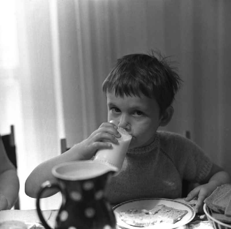 Zwei Tage im Leben einer alleinerziehenden Frau mit zwei Kindern in Ostberlin. Zwischen Privatem, Arbeit und Weiterbildung ( EDV Kurs ). Die Familie sitzt am Tisch und ißt Abendbrot, ein Mädchen trinkt Milch aus einem Glas.