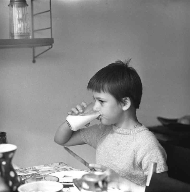 Zwei Tage im Leben einer alleinerziehenden Frau mit zwei Kindern in Ostberlin. Zwischen Privatem, Arbeit und Weiterbildung ( EDV Kurs ). Die Familie sitzt am Tisch und ißt Abendbrot, ein Mädchen trinkt Milch aus einem Glas.