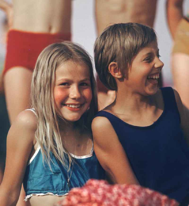 Zwei Mädchen genießen ihre Ferien im Sommer 1971 im Freibad in Berlin Pankow. Viele Kinder und Jugendliche, die nur einen Teil der acht Wochen langen Sommerferien in Ferienlagern und bei ihren Verwandten verbringen konnten, verlebten in Freibädern wie diesen ihre schulfreie Zeit.