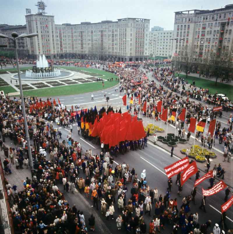 Tausende Menschen - teils mit Plakaten, Transparenten und Fahnen - laufen zur traditionellen Demonstration in der Hauptstadt der DDR am 1. Mai 1974, dem 'Internationalen Kampf- und Feiertag der Werktätigen für Frieden und Sozialismus', auf der Berliner Karl-Marx-Allee am Strausberger Platz in Richtung Alexanderplatz.