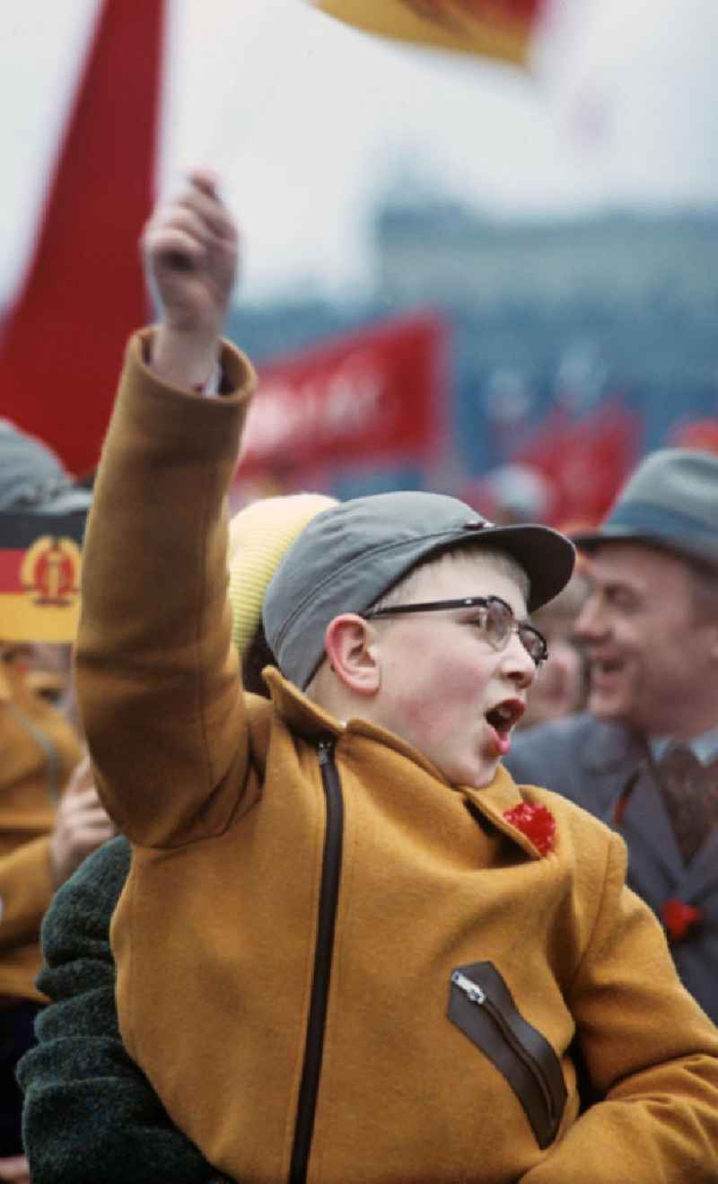 Begeistert schwenkt ein Junge mit roter Nelke im Kragen zur traditionellen Demonstration am 1. Mai 197