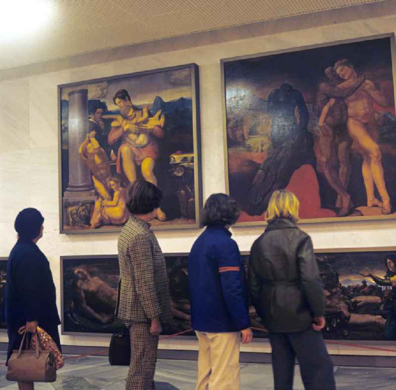 Kurz nach seiner Eröffnung am 23. April 1976 besichtigt eine Besuchergruppe im Palast der Republik (PdR) in Berlin die fünfteilige Gemäldegruppe 'Mensch - Maß aller Dinge' von Werner Tübke In den Foyers des Kulturpalastes hingen mehrere großformatige Gemälde von 16 prominenten Künstlern und Malern der DDR, viele im Stil des Sozialistischen Realismus.