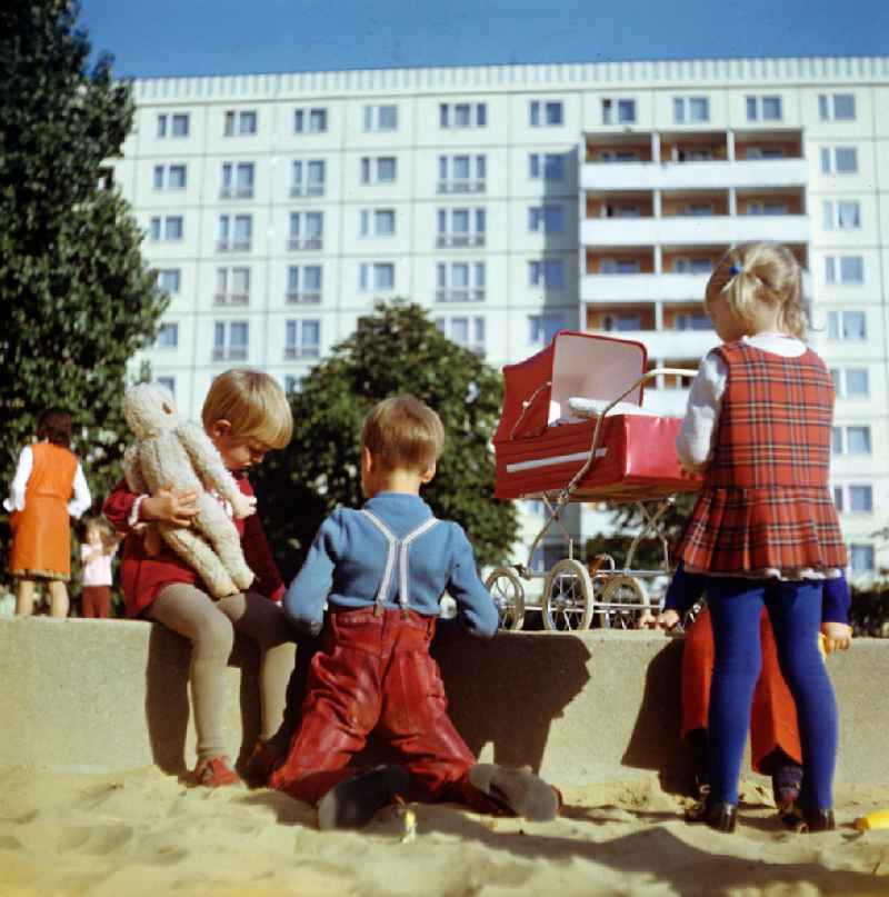Kinder spielen in einem Sandkasten auf einem Spielplatz in einem gerade errichteten Neubauviertel in Berlin.