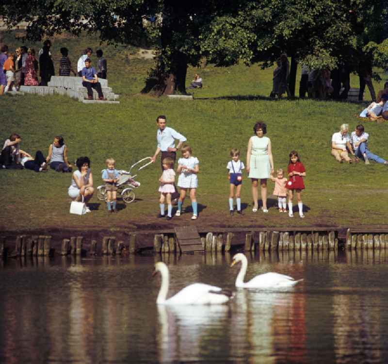 Viele junge Familien und Paare zieht es in der warmen Sommersonne in den Volkspark Friedrichshain in Berlin. Der Park mit seinen vielen großen Liegewiesen, den Springbrunnen und Spielplätzen war bei den Berlinern ein beliebter Ort zur familiären Naherholung.