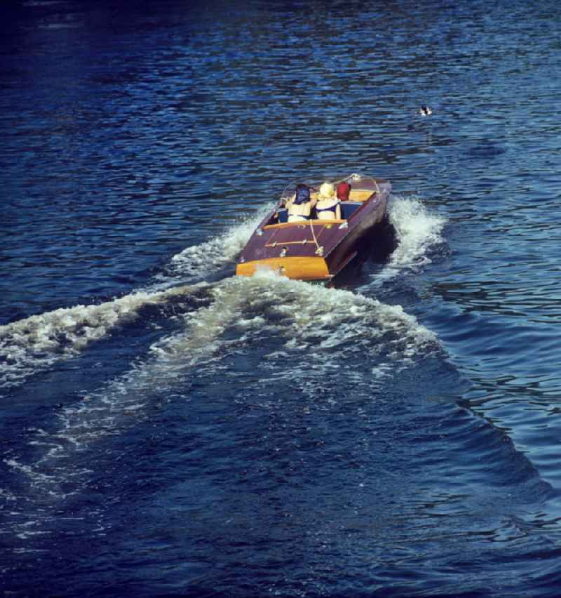 Bei hochsommerlichen Temperaturen genießen diese leichtbekleideten jungen Damen ihren Ausflug mit dem Motorboot und wird dabei von einer Ente 'begleitet'.