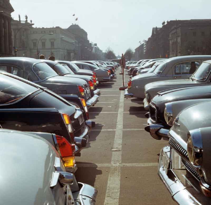 Blick über die parkenden Autos auf dem Mittelstreifen Unter den Linden in Berlin-Mitte Richtung Brandenburger Tor.