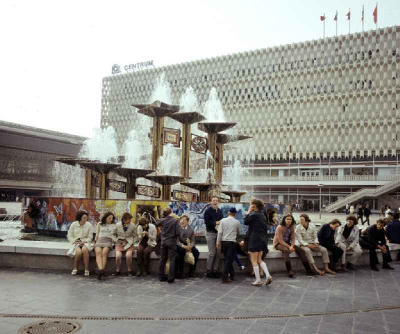 Jugendliche sitzen am Brunnen der Völkerfreundschaft auf dem Berliner Alexanderplatz. Der 197