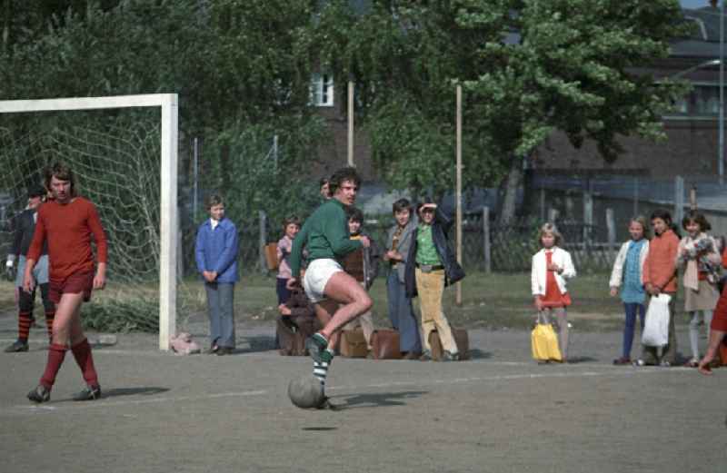 Neugierig beobachten Schüler den DDR-Schlagerstar Frank Schöbel beim Fußballtraining auf dem Sportplatz einer Berliner Schule. Im selben Jahr hatte er zur Eröffnung der Fußballweltmeisterschaft in der BRD den Song 'Freunde gibt es überall' gesungen.