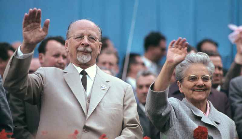 Anläßlich einer Demonstration zum 1. Mai stehen der Erste Sekretär der SED und Vorsitzende des Staatsrates der DDR, Walter Ulbricht, und seine Ehefrau Lotte auf der Ehrentribüne und winken den Demonstranten zu.