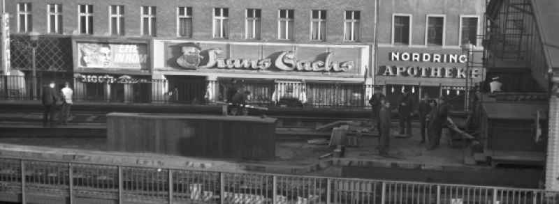 Mit großen Buchstaben laden das Kino 'Skala', das Schuhgeschäft 'Hans Sachs' und die 'Nordring Apotheke' in der Schönhauser Allee in Berlin zu einem Besuch ein. Entlang der Schönhauser Allee, der beliebtesten Einkaufsstraße im Berliner Osten, verläuft die U-Bahnlinie über der Erde.