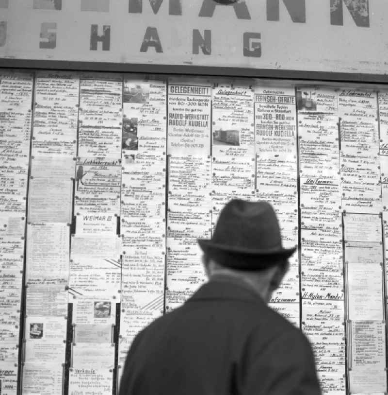Ein Passant steht vor einem Geschäft in der Schönhauser Allee in Berlin-Prenzlauer Berg und studieren die ausgehängten Anzeigen auf der Suche nach einem Schnäppchen. Die Schönhauser Allee gehörte zu den beliebtesten Einkaufsstraßen im Berliner Osten.