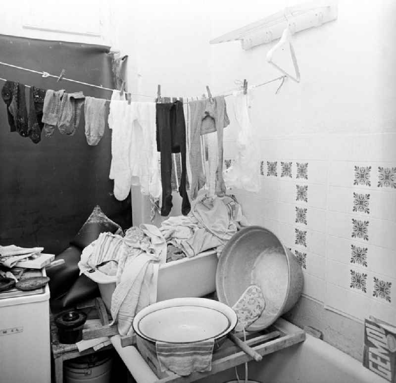 Ein Berg Wäsche türmt sich im Bad in einer Wohnung in der Gormannstraße in Berlin. Wohnungen gehörten in der DDR zur Mangelware. Eine freie Wohnung zu erlangen, war in der Regel kein leichtes Unterfangen - entweder wurde getauscht oder es mußte ein dringender Bedarf, z.B. die Geburt eines Kindes, nachgewiesen werden. So war der zur Verfügung stehende Wohnraum oft beengt und man mußte sich bei Altbauwohnungen mit schlechter Ausstattung wie Gemeinschaftstoilette im Treppenhaus und aufwendiger Ofenheizung zufrieden geben.