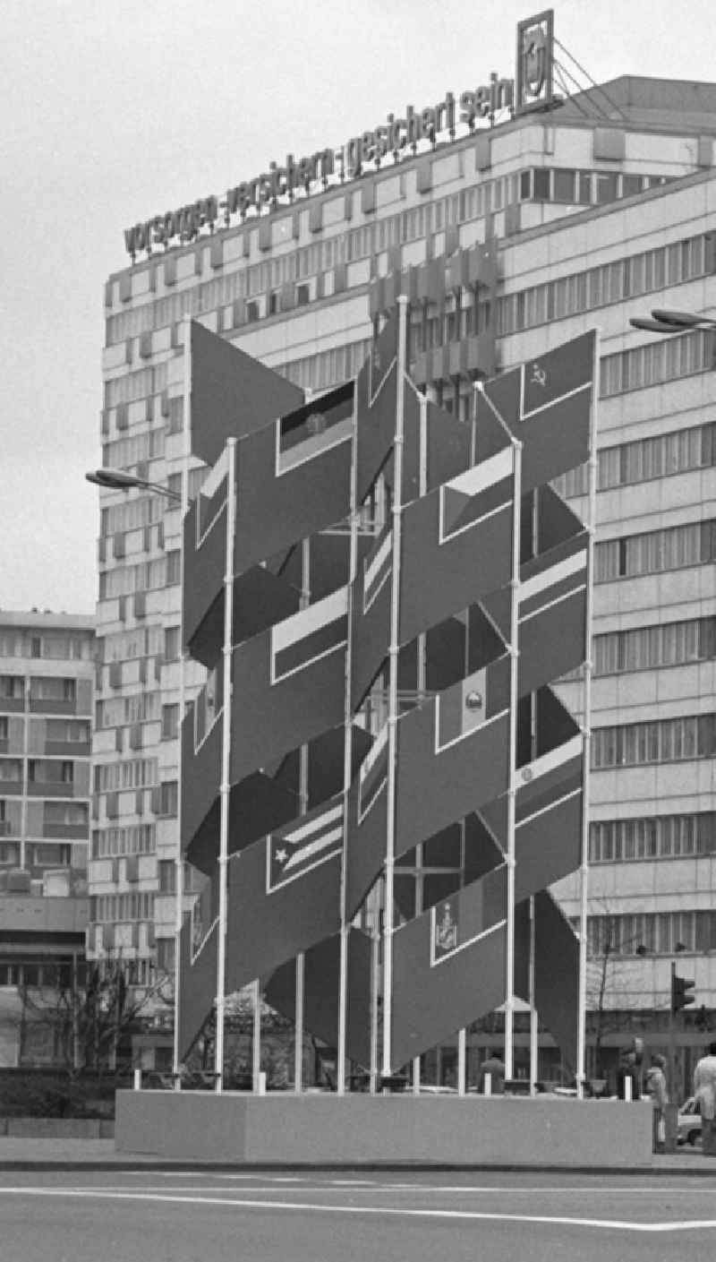 Eine Säule aus internationalen Flaggen - sogenannte Sichtwerbung - wirbt für den IX. Parteitag der Sozialistischen Einheitspartei Deutschlands (SED) vor dem Haus der Elektroindustrie am Alexanderplatz in Berlin.
