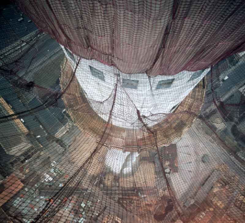 Blick durch die Fangnetze auf den Schaft des im Bau befindlichen Fernsehturms in Berlin. In nur 52-monatiger Bauzeit wurde das über 300 Meter hohe Bauwerk im Zentrum von Ost-Berlin errichtet und am