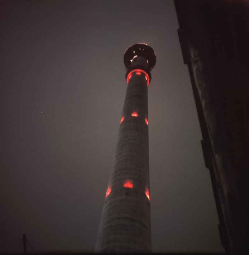 Nachtaufnahme des leuchtenden, im Bau befindlichen Fernsehturm in Berlin.